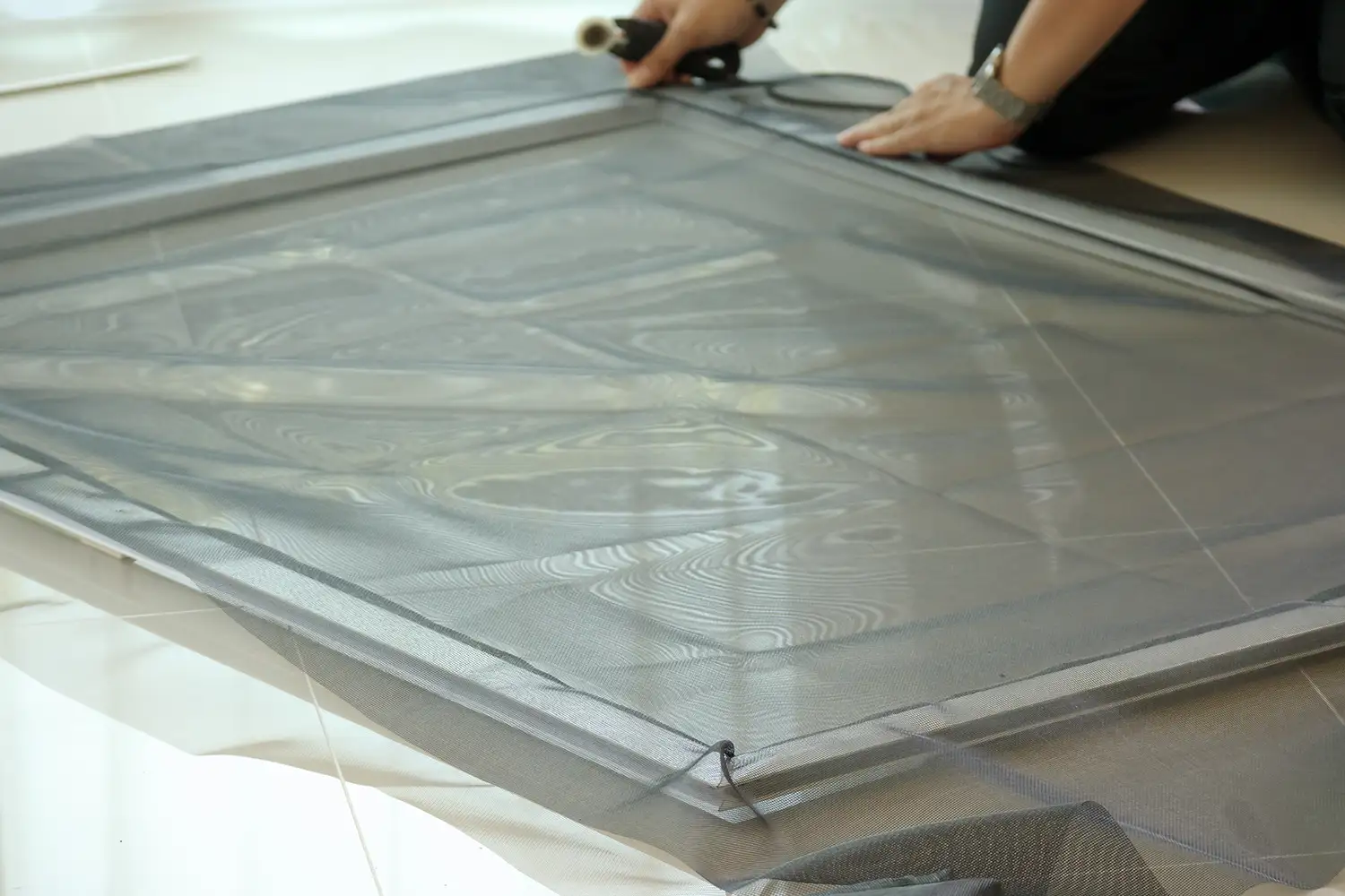 Window screen professional measuring a frame for installation in Vancouver, WA.
