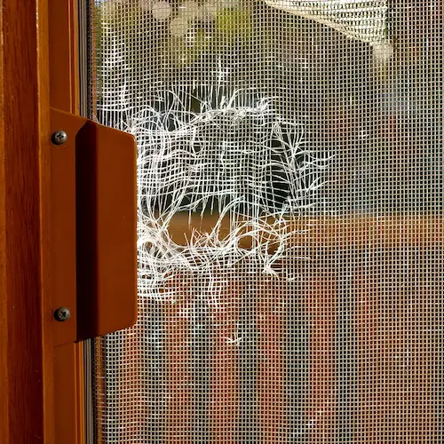 Frayed whole in a sliding screen door