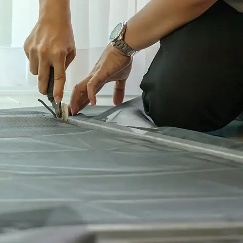 Technician setting a screen to it's frame